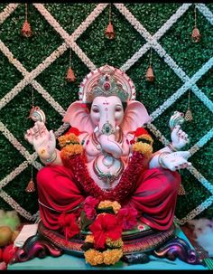 an elephant statue sitting on top of a table next to a wall covered in greenery