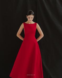 a woman in a red dress is standing against a black background with her hands on her hips