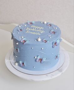 a blue birthday cake with butterflies on it