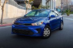 a blue car is parked on the street