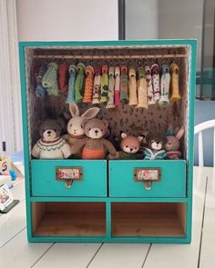 an open cabinet filled with stuffed animals on top of a table