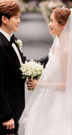 the bride and groom are looking at each other