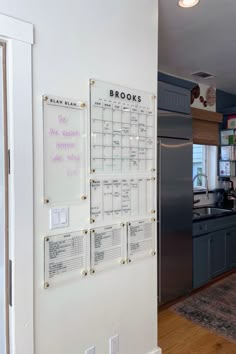 a kitchen with a refrigerator and a wall calendar on it's glass door frame