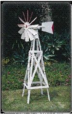 a white wooden windmill sitting on top of a lush green field