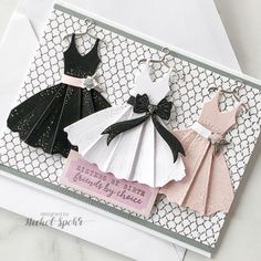 three different types of dresses on a card with white and black trimmings, one in the shape of a bride's dress