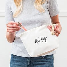 a woman holding a white bag with the word bride written on it in gold foil