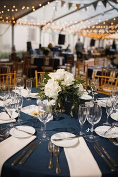 the table is set with white flowers and place settings for dinner or other special event