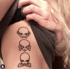 a woman's back with three skulls and bones on her stomach, one is holding the