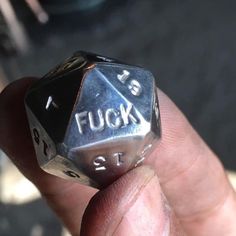 a close up of a person holding a metal dice