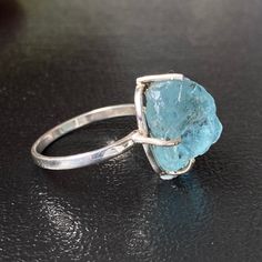 Natural Aquamarine Sterling Silver 925 Ring. Aquamarine is in raw form originating from Africa. It has a beautiful intense vivid blue color. ITEM DETAILS: * Gemstone: Aquamarine * Origin: Brazil and Africa * Stone Size: 8-12MM * Ring Size: US ring size From 000-16 * Setting: Prongs- 4 * Metal: Sterling Silver 925 * Band Color Options: Silver, Rose Gold Overlay, Gold Overlay ABOUT AQUAMARINE: * Beautiful Ring and the stone of 2021. * Aquamarine is a literal Translation of Water from the Sea or St Aquamarine Gemstone Crystal Ring Gift, Aquamarine Crystal Gemstone Ring Gift, Aquamarine Gemstone Crystal Ring For Gift, Aquamarine Crystal Ring With Gemstone For Gift, Adjustable Aquamarine Gemstone Rings, Unique Handmade Aquamarine Rings, Unique Aquamarine Rings For Gifts, Unique Aquamarine Rings For Gift, Aquamarine Ring Jewelry Gift