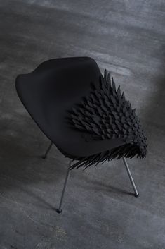 a black chair sitting on top of a cement floor