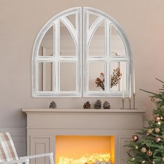 a fireplace with a christmas tree in front of it and a mirror on the wall