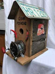 a wooden birdhouse with fishing gear on it