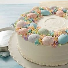 there is a cake decorated with eggs and flowers on the top, along with silverware