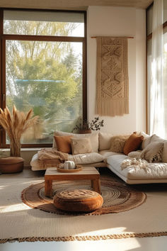 a living room filled with lots of furniture next to large windows and a rug on the floor