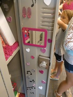 a girl is standing next to a locker with musical notes on it and pink accents