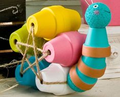 colorful toy snail sitting on top of a table next to a potted plant and other items