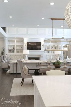 a living room filled with white furniture and lots of windows