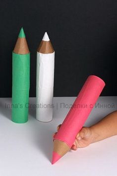 three colored pencils sitting next to each other on a table