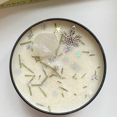 a bowl filled with ice and sprinkles on top of a white table