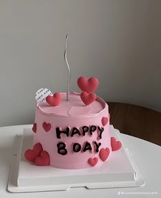 a pink birthday cake with hearts on it