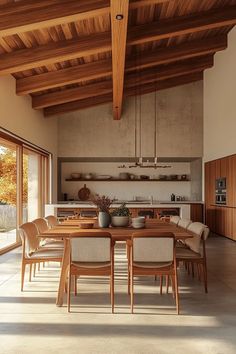 a dining room table and chairs in front of an open kitchen