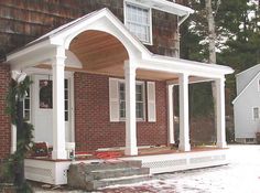 a small brick house with porch and columns