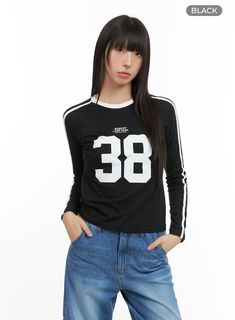 blokecore-cotton-lettering-raglan-crop-top-cg420 / Black College Stretch T-shirt With Letter Print, Black Tops With Number Print For College, Black Top With Graphic Print, Casual Style, Trendy Long Sleeve Sports T-shirt, Trendy Black Tops For College, Black Athleisure Tops For College, Black Long Sleeve Varsity T-shirt, Trendy Black Tops For School, Black Tops For College In Spring