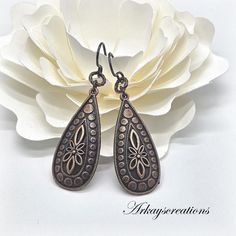 For a touch of vintage charm, these Embossed Copper Teardrop Earrings feature a beautiful floral design that adds depth and dimension.  These earrings are a perfect anniversary gift. They'll add a touch of sophistication to any outfit. The warm tones of the copper create a beautiful contrast, making these earrings a versatile accessory for any occasion. Measurements: 2.09″ (53.1 mm) length 0.60″ (15.3 mm) width Materials: Embossed Copper Teardrops Handmade Antique Copper Ear Wires or Dark Charco Elegant Copper Teardrop Earrings, Vintage Metal Teardrop Pierced Earrings, Vintage Metal Teardrop Earrings, Ornate Antique Finish Earrings For Gifts, Antique Finish Copper Drop Earrings, Ornate Antique Finish Earrings As Gift, Bronze Metal Teardrop Earrings For Gift, Elegant Brass Flower Earrings Nickel Free, Vintage Collection Metal Drop Earrings