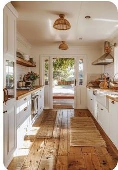 an open kitchen with wooden floors and white cupboards on the walls, along with wood flooring