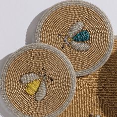 two woven baskets with beaded designs on the sides, one has a blue and yellow bee