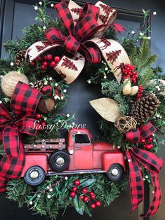 a christmas wreath with a red truck and pine cones