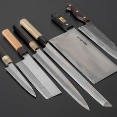 several knives are lined up next to each other on a black surface with knife sharpeners