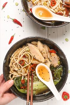 two bowls filled with noodles, meat and vegetables