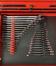 a red tool box filled with lots of wrenches and spanner's bits