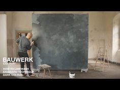 a man is painting the walls in an empty room