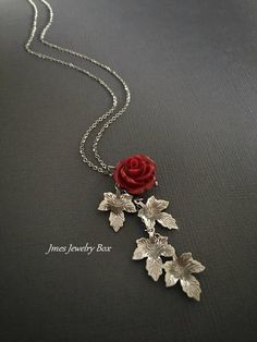 Beautiful red resin rose with dangling silver leaves. Detailed stainless steel leaves measure 15.5mm x 11mm. Total pendant length with rose and leaves is just over 2 inches. This necklace is 18'' long with lobster clasp. *15mm Resin rose *Stainless steel chain *Stainless steel leaves *Handmade with love <3 Like Jmesjewelrybox on Facebook for updates on new jewelry, upcoming sales and giveaways! Plus Facebook fans save 5% :D Find the coupon code on Jmesjewelrybox's cover photo https://www.face Elegant Rose Red Flower Necklaces, Rose Red Necklace, Gift Red Rose Necklaces, Red Flower Pendant Jewelry With Rose Design, Rose Branch, Red Flower-shaped Necklace With Rose Design, Resin Rose, Dangle Necklace, Branch Necklace