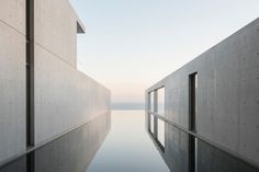 an empty pool in the middle of a building with water reflecting off it's sides