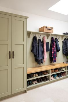 a coat rack filled with coats and shoes next to a wall mounted shoe storage unit