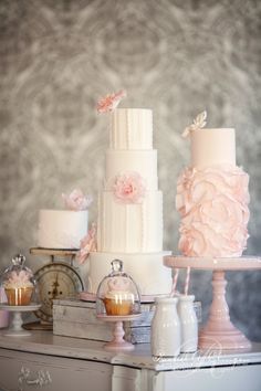 three tiered wedding cakes with pink flowers on them