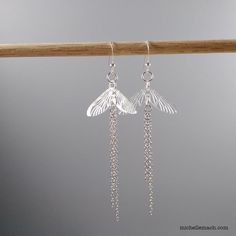 Celebrate nature with these pretty dragonfly wing earrings! The dragonfly wings are based on an original drawing and custom engraved on lightweight clear acrylic. The earrings are finished with four strands of fine stainless steel chain which give these long earrings movement when worn. Length:  3 1/2" (longest chain) Length is measured from the top of the ear wire (the part that will be in your ear) to the bottom of the last chain link. Ear wires: Sterling silver Sterling silver ear wires are more expensive than silver-plated, but are generally a better choice for those with metal sensitivities.  (The plating can wear off in cheaper silver-plated earrings, leaving the base metal exposed.) Pretty Dragonfly, Dragonfly Wings, Detailed Jewelry, Wing Earrings, Snowflake Designs, Seasonal Gifts, Steel Chain, Ear Wire, Original Drawing