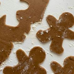 three gingerbread cookies with icing on a white surface