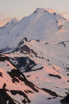 a mountain covered in snow at sunset