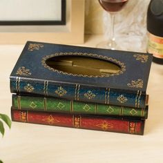 three books sitting on top of each other next to a glass of wine and a bottle