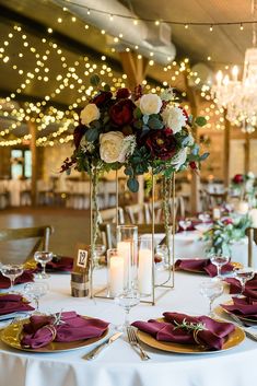 the table is set with candles, plates and napkins for an elegant wedding reception