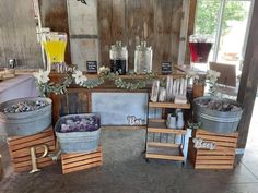 an assortment of wine bottles, glasses and other items on display in a room with corrugated walls