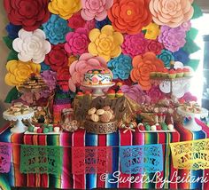 colorful paper flowers are on display at a mexican themed party