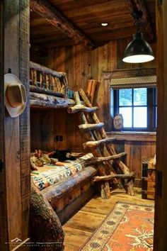 a bunk bed made out of logs in a room with wooden walls and flooring