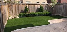 a backyard with grass and wooden fenced in area next to the yard is well manicured