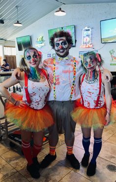 three people dressed up as clowns posing for the camera